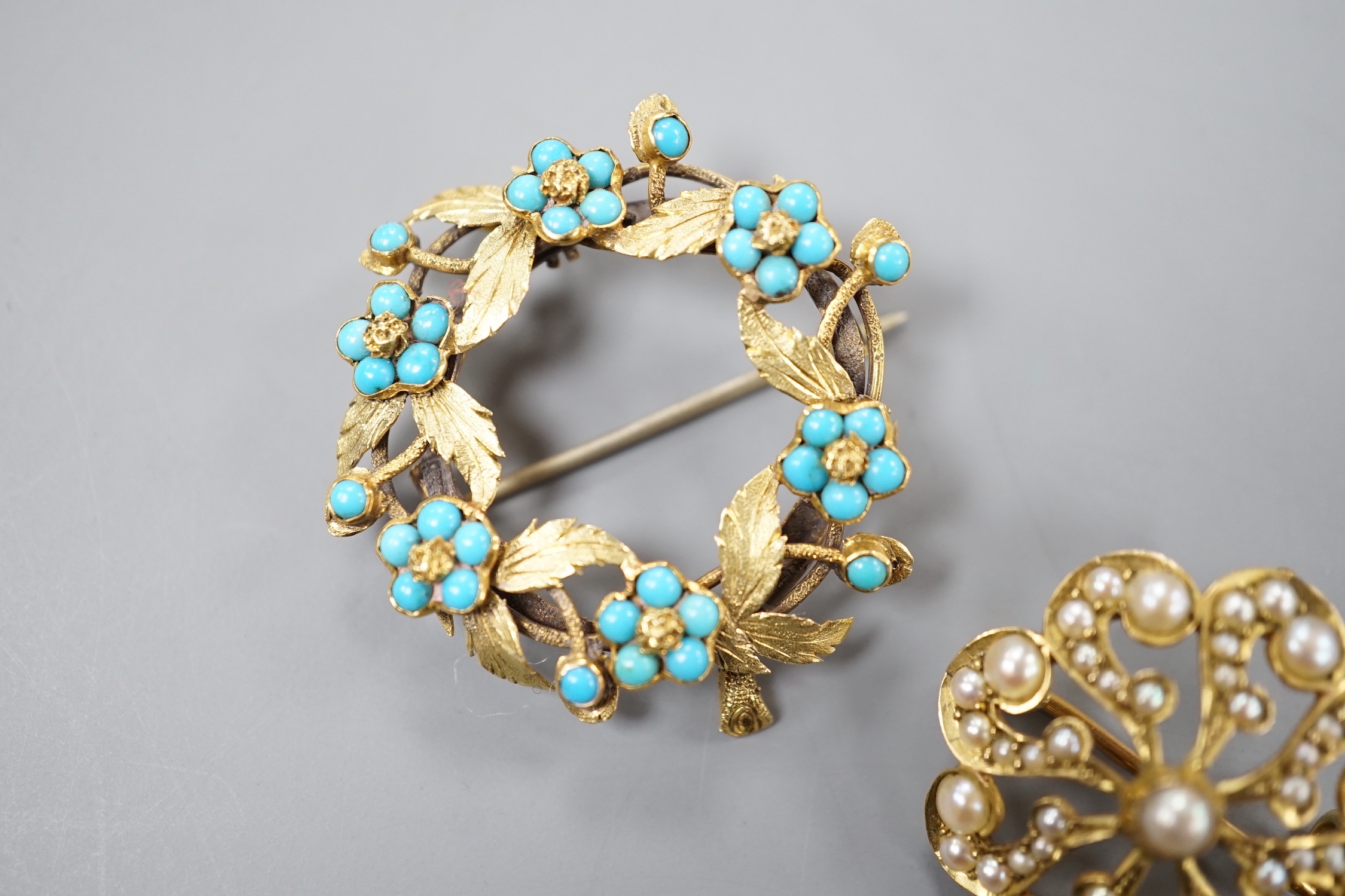 An Edwardian 9ct and seed pearl set brooch, 23mm and a yellow metal and turquoise set wreath brooch, gross 9.3 grams